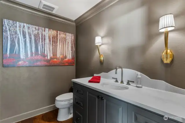 Powder room lies off the formal living room. Elegant antique brass faucet and circa lighting fixtures.