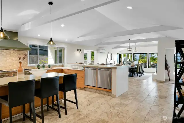Vaulted ceilings and two additional areas for seating (at the kitchen island and counter to the right) mean there's room for MANY guests and, of course, company for chef while busy making the magic happen!