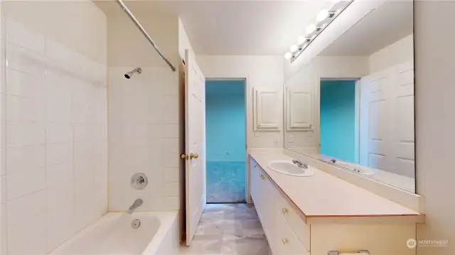 The large full bath has a tile surround bathtub/shower combo.