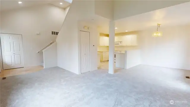 With an open concept, the living room looks to the entry with coat closet on the left and the kitchen & dining room on the right.  Notice the vast storage closet under the stairs.