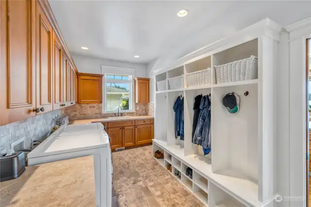 The laundry room has built-in coat and shoe storage. The door to the right leads to the kitchen.