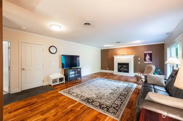 Downstairs with new engineered hardwood floor, gas fireplace, sliding door to patio and fenced backyard.