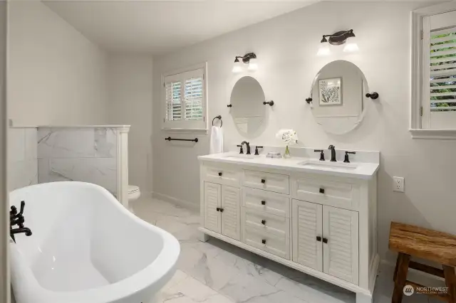 Updated primary bathroom includes claw-foot tub wand walk-in shower