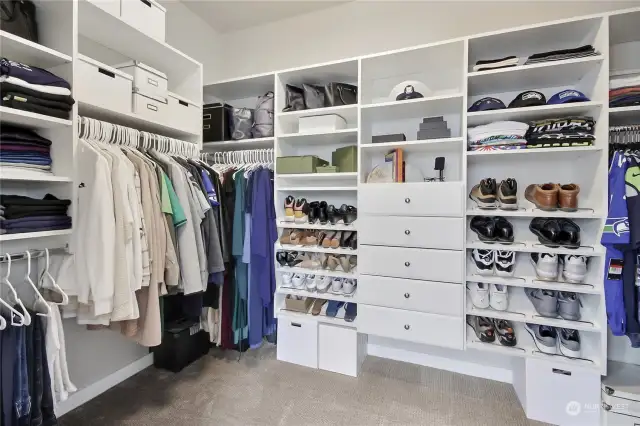 Large primary closet with custom buildout.