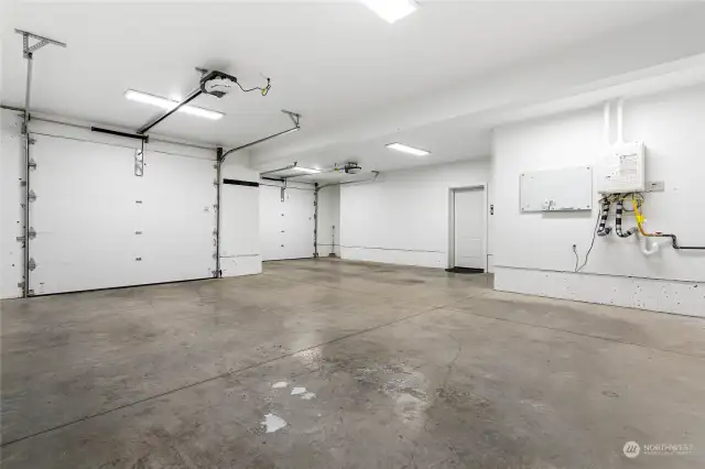 So much room in this XL 2+ car garage. Here you will find ample room for all of your outdoor gear or tools. The efficient tankless water for the house is located here, as well as the set up for an electric car charger if you desire.
