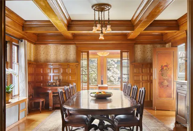 Rich oak paneling and heavy box beam ceiling provides a sumptuous feel to a true formal dining room. Period lighting, cut-glass pocket doors and a hand-painted wooden panel.  Note the beautiful antique chandelier with the tulip motif.