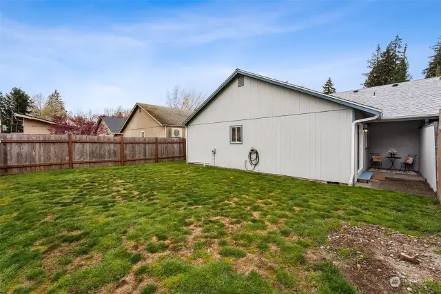Fully fenced yard has side access through gate as well as access from covered patio.