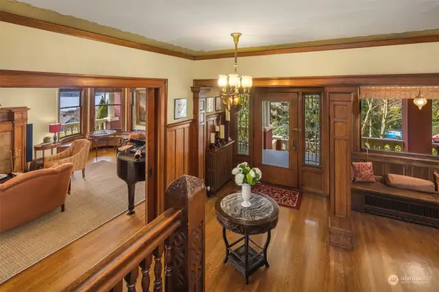 Gracious entry foyer with original millwork, pocket doors, original light fixture plus large coat closet and entry bench.  The large glass front door is flanked by leaded glass side lights.