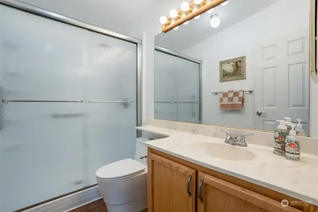 The guest bath enjoys a Bath Fitter walk-in shower and newer toilet.