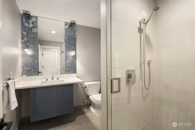 Main floor guest bathroom, quartz counters, floating vanity and standing shower.