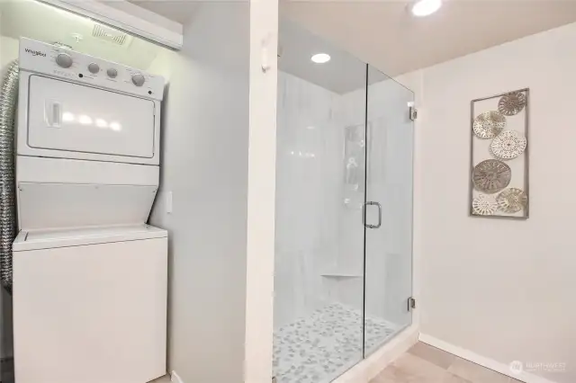 Remodeled bathroom with framless shower door, pepple floor, and tiled shower.