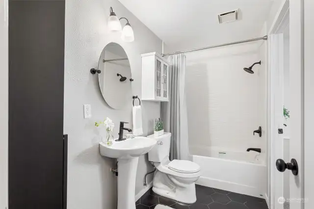 Fully remodeled with modern black and white finishes. New hexagon tile flooring, new insulated American Standard soaker tub, new "wavy" shower tile, new pedestal sink, new mirror, new wall-mounted cabinet, new doors and trim, new paint, new fixtures. All yours to enjoy!