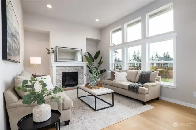 The great room has a gas fireplace and area for bookshelves on either side.  The tall ceilings and lots of glass add to the spacious and light feel of this home.