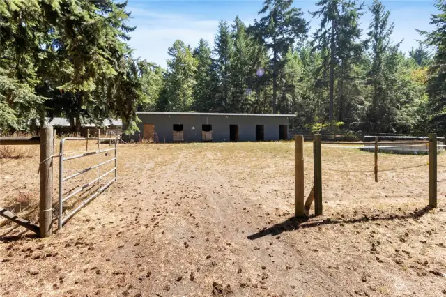 Back parcel features arena/pasture area + 6 stall stable.