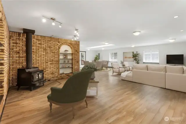 *This photo has been virtually staged* HUGE family room with wood burning stove, brick accents & built-in shelving, laminate hardwoods throughout.