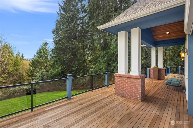 Rear deck with a covered vaulted cedar porch ceiling and overhead lighting. Glass and metal railing with steps to the backyard.  Gas line for Grill on deck in 2 places.