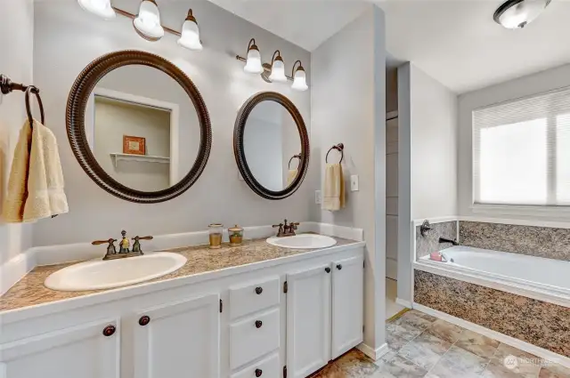 Double vanities and plenty of cabinets adorn the primary bathroom suite.