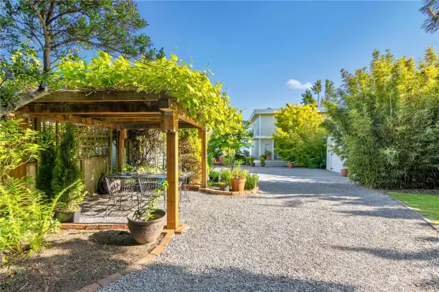 Upon entering the private 14-foot drive, you're greated by a beautiful garden and green space (on the right) and a luscious pergola on the left, perfect for dinner al fresco.