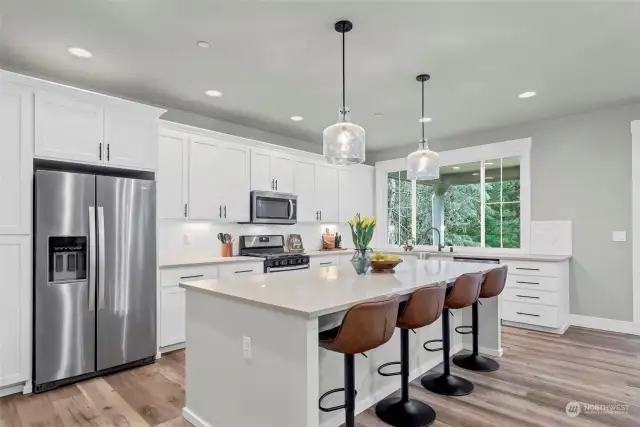 Welcome to the sleek white kitchen with large island and plenty of storage to go around.