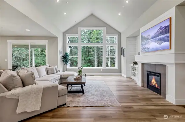Giant wood-wrapped windows flood the vaulted great room and open concept with natural light and a gorgeous backdrop.