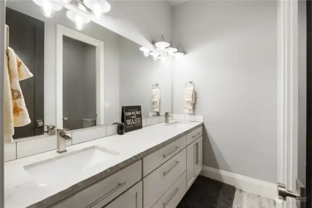 Guest bath offers a dual vanity and separate water closet.