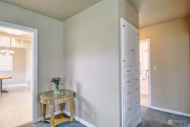 Partial view of the entryway reveals easy access to the kitchen, dining area, laundry room, and rear bonus room to the left. On the right, the living room, while the hallway leads forward to the bedrooms and bathroom.