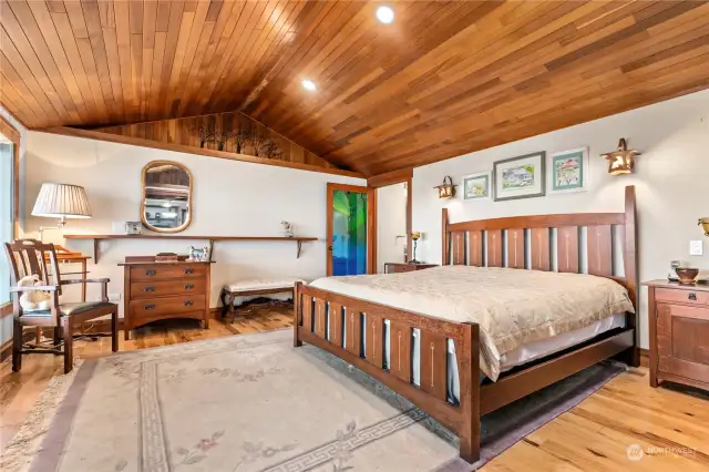 The primary bedroom has gracious wood with frosted lite french doors to create privacy. That amazing stained glass door opens to the private bath.