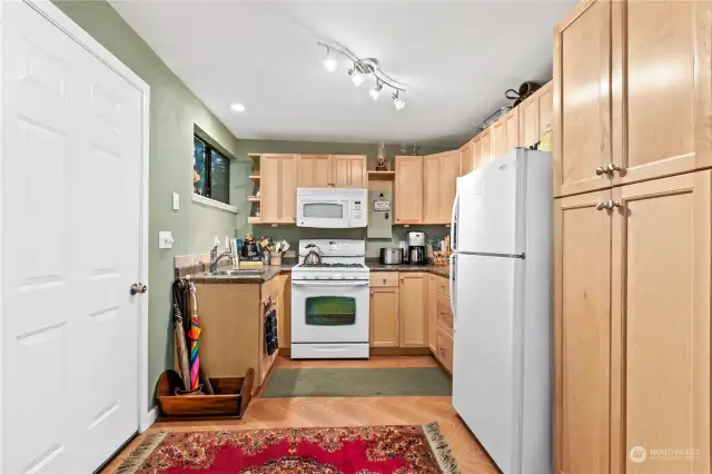 The mini home kitchen has full sized appliances and cupboards, we call that efficient and it's cute too.