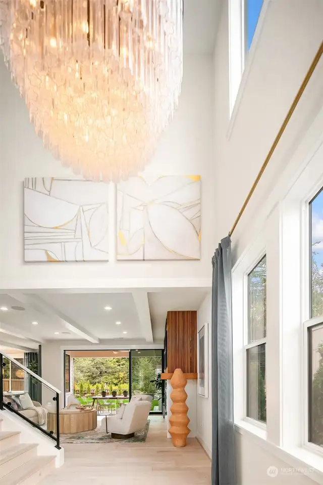 Lofty 2-story foyer with impressive chandelier and expansive windows for natural light