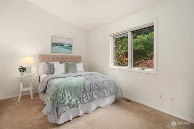 Wake up to a charming scene – this upper-level bedroom offers a front-yard view framed by lush greenery.