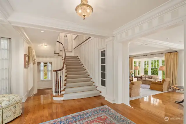 Presenting gleaming pecan floors accented by a sweeping grand staircase with hand turned railings and custom pecan handrails.