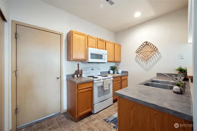 Inside the kitchen, with the door leading directly into the two car garage. All appliances are included.