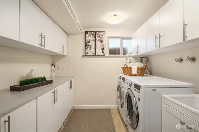 Large laundry room with utility tub, lots of storage, and room for an extra refrigerator.