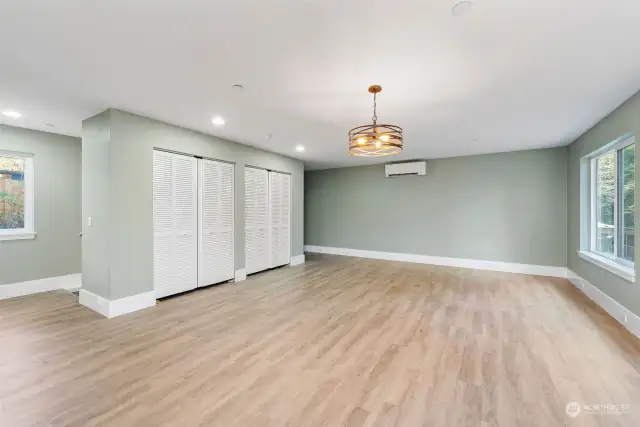 Great Room features 2 storage closets. Behind closets is stairway to garage/shop area. To left of Mini-Split are the stairs to the second floor.