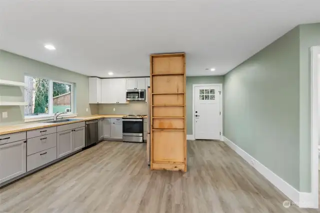Kitchen boasts trending, colored cabinets with accented white upper cabinets, Butcher Block counters and Stainless appliance package. Large window by sink for views of wooded area in front of home.
