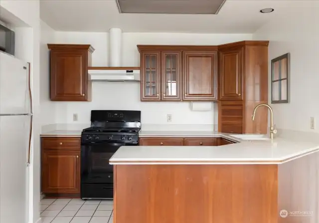 lower level kitchen with range/oven, microwave and refrigerator convey