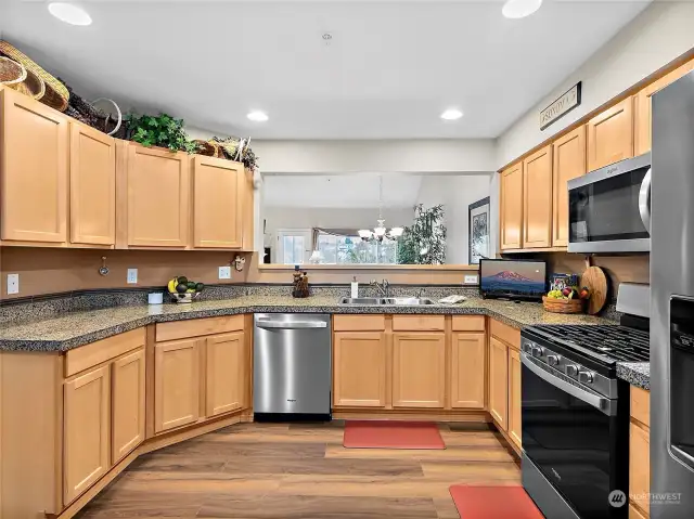 Sleek and modern kitchen with new stainless steel appliances, granite countertops and new flooring.