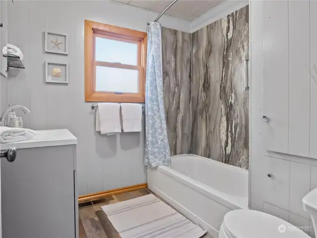 Full bathroom with vinyl plank flooring.