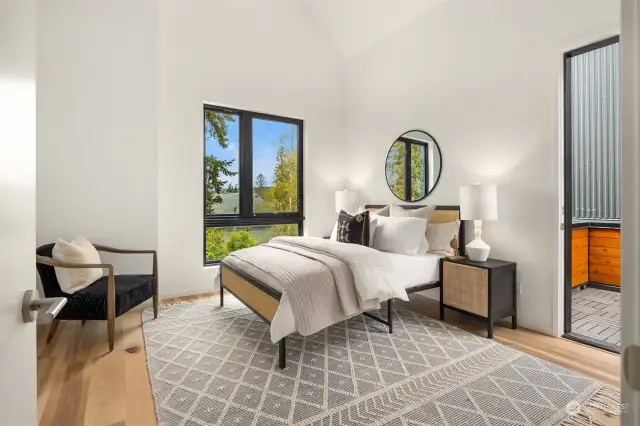The primary bedroom boasts soaring ceilings, access to the roof deck, large windows, and an abundance of natural light, creating a tranquil and airy retreat within the home.