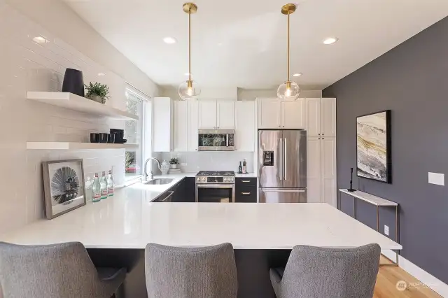 Stunning European Kitchen with marble countertops, stainless steel appliances, pull out pantry, under cabinet lighting and designer pendant lighting.