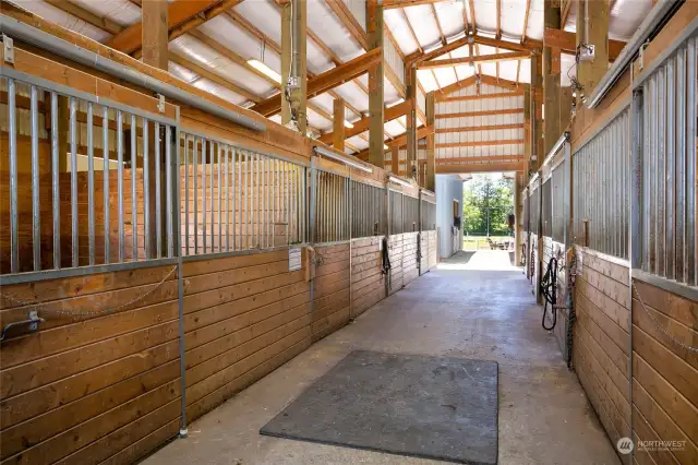 Interior of newer 11 stall barn each with own paddock. This barn also has own tack room and cross ties.