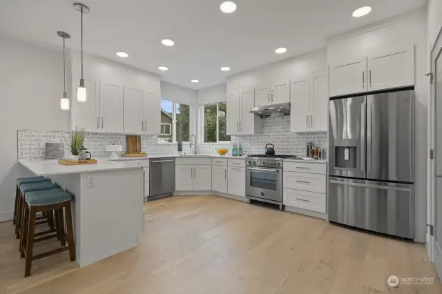 4019B impressive kitchen featuring stainless appliances, gas range, eating bar, quartz counter tops, tile backsplash and walk in pantry.