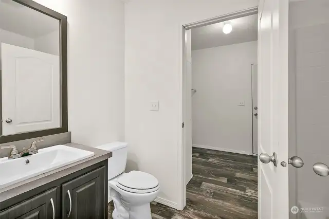 Full bathroom with tub/shower, leads into the laundry, and a door to the outside as well