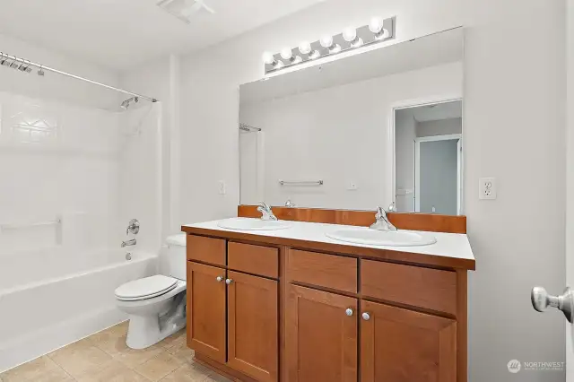 Full bathroom upstairs with 2 sinks and storage closet.