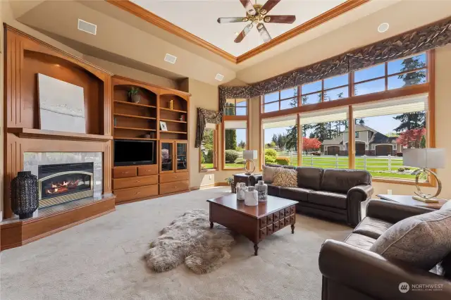 Stylish yet comfortable family room with coffered ceiling, crown molding, built in cabinetry, bookcases & fireplace. Large picture windows overlook the manicured backyard and outbuildings.