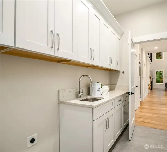 Laundry room conveniently located right off  the kitchen has a deep stainless utility sink,  Quartz counters, and tons of cabinets.