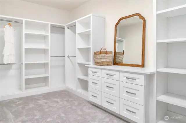 Walk in closet off primary ensuite has built in  cabinets, carpet and loads of storage space!