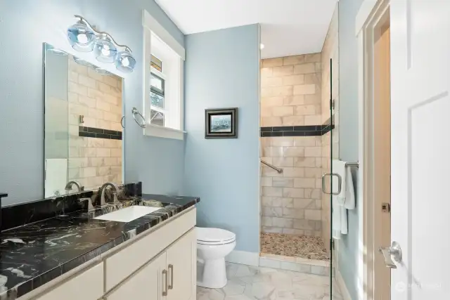 The second Primary Bathroom is beautifully enhanced by custom, blue Bi-Cycle glass fixtures, granite countertops, huge walk-in closet, and walk in Shower.