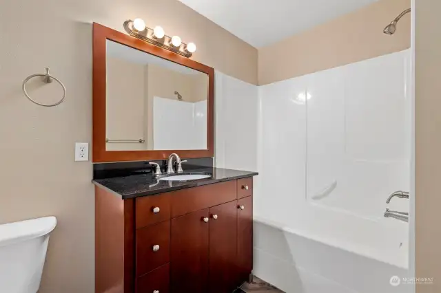 The full bath also has the same cabinets and granite counters as the kitchen.