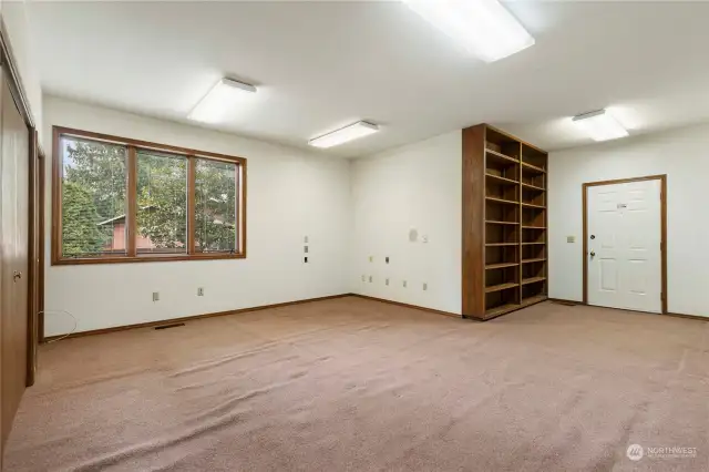 Enormous office/den or studio or great room off of the back hallway, with built ins + workbench & door that leads outside.  Side-gig or in-home business potential perhaps?!